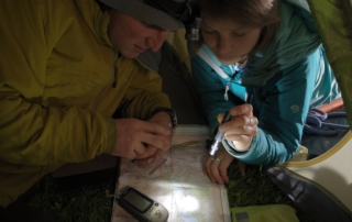 Hikers reading their map using flashlights