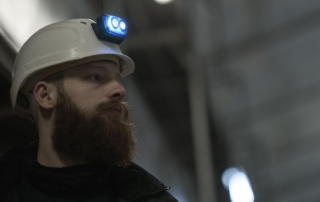 Electrician working on a construction site, with a S4 rechargeable headlamp mounted on his safety helmet